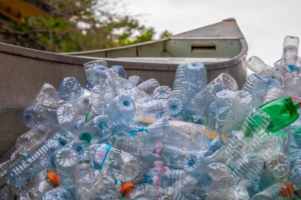 photo of the canoe resting on a sea of bottles