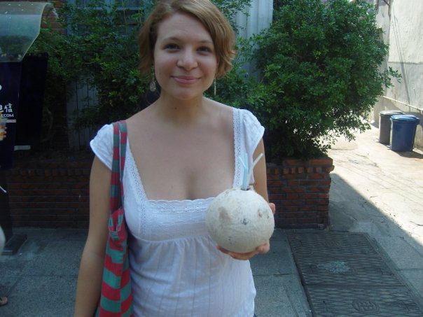 Sophie holds a coconut with several plastic straws sticking out