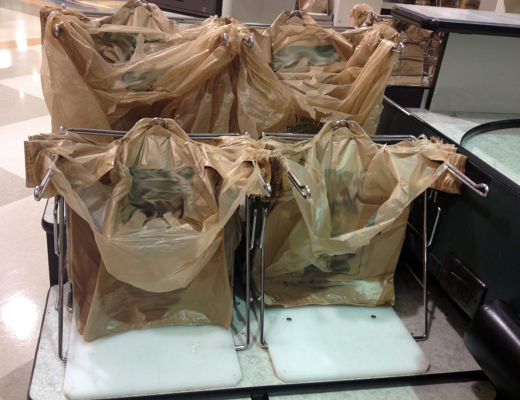 Plastic bags at grocery store checkout counter.