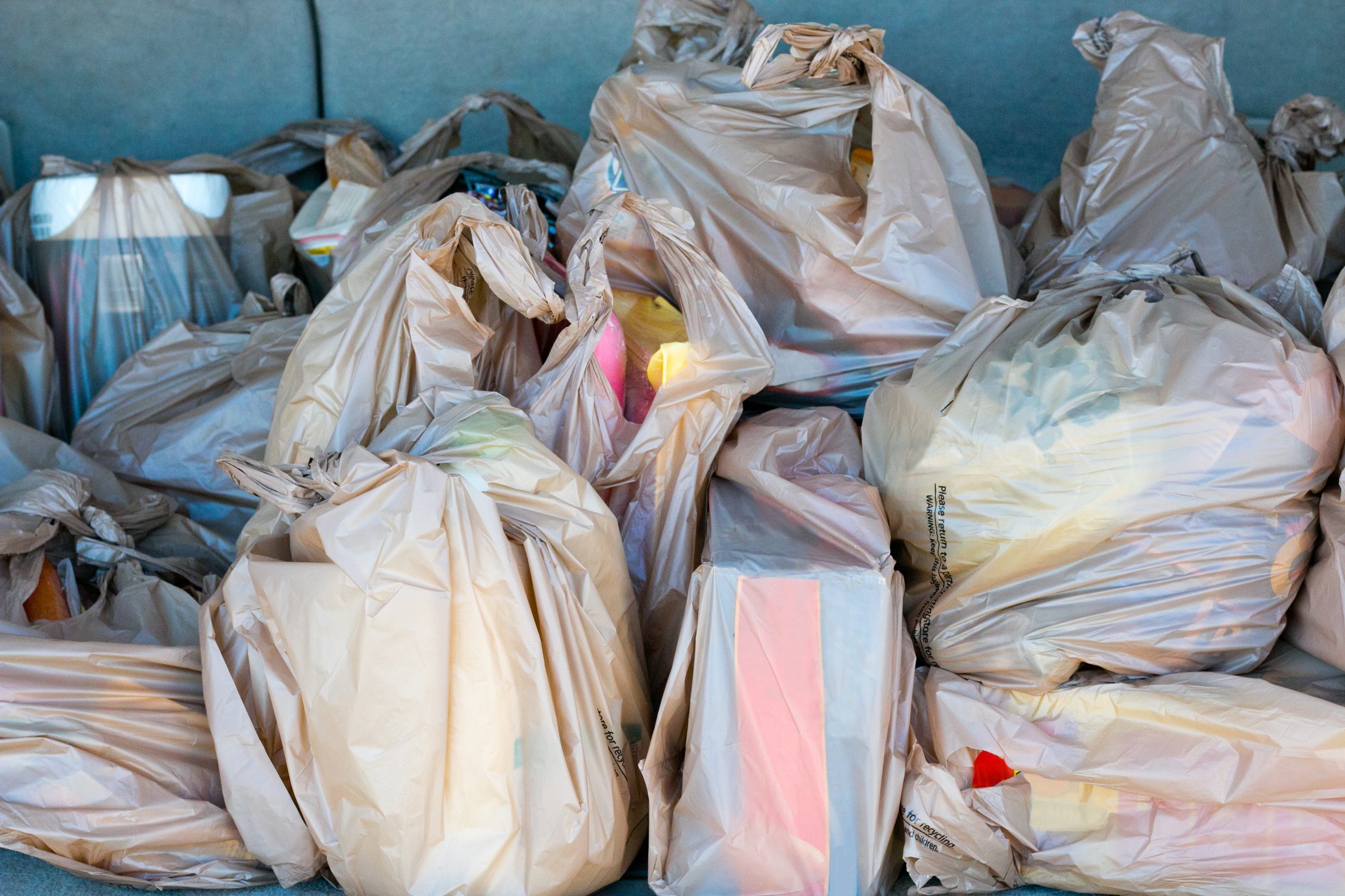 Plastic bags full of groceries in the trunk of a car