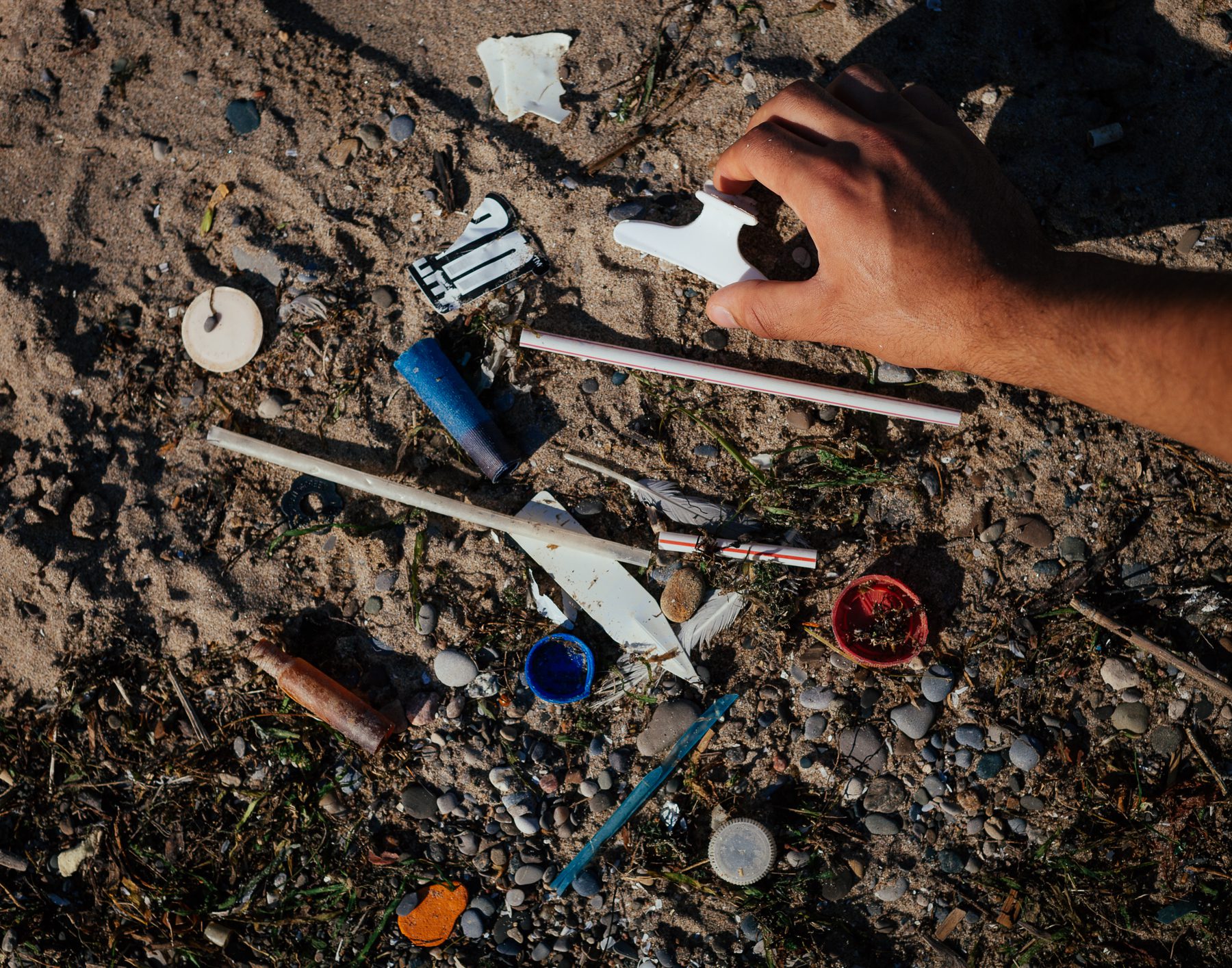 Mohamad sorts through a collection of garbage he found in less than a minute along Seacliff Beach.