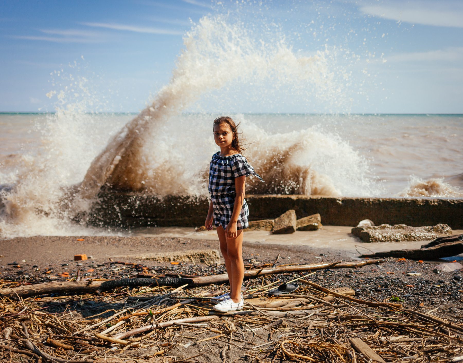 Michelle’s daughter stands on the eroded shoreline and what remains of Burns Beach. 