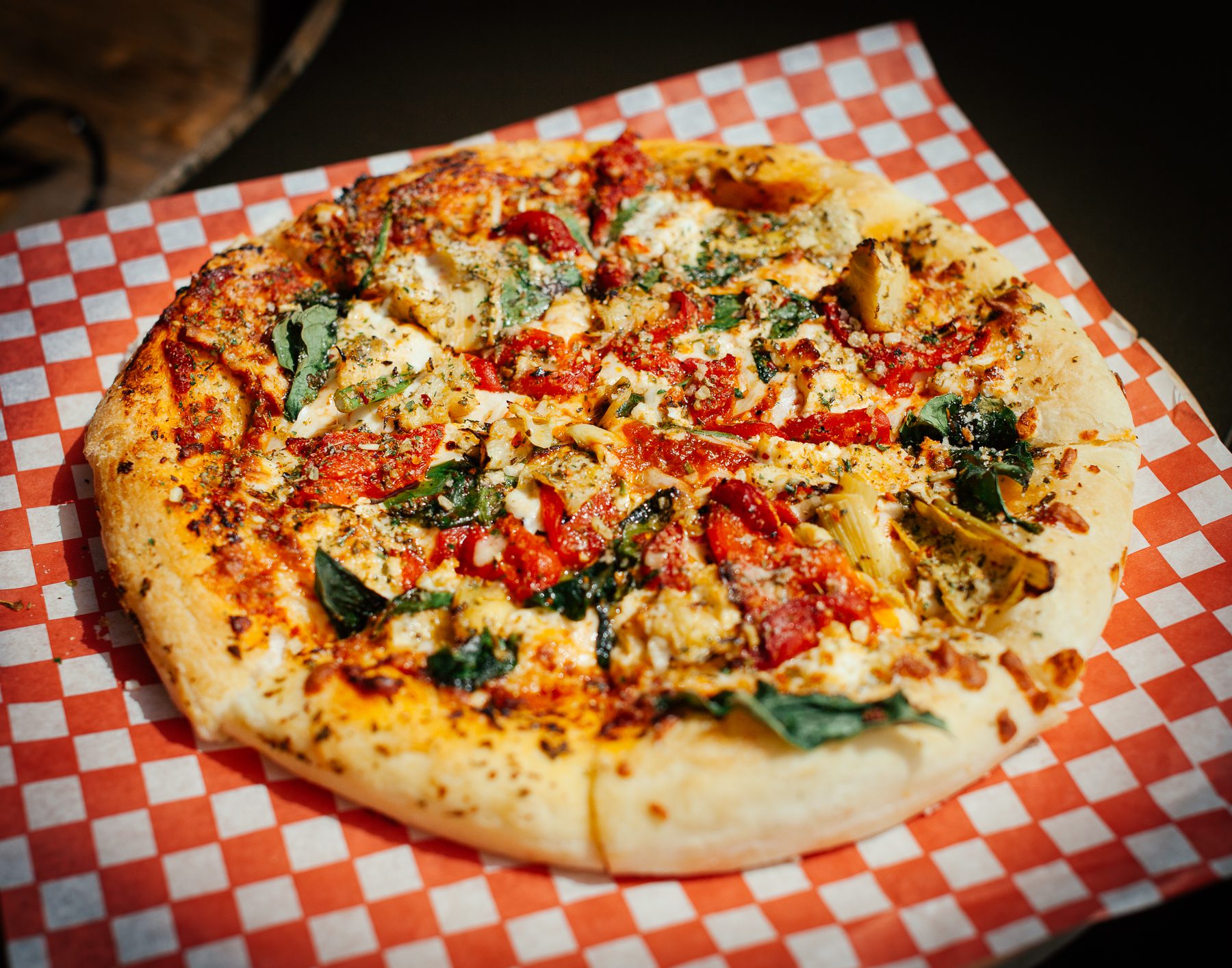 Anthony’s son, Sebastian, who is 19 and serving at the restaurant. Here he holds“the Greek Pie,” a pizza featuring spinach, feta cheese, artichokes, and roasted red peppers. 