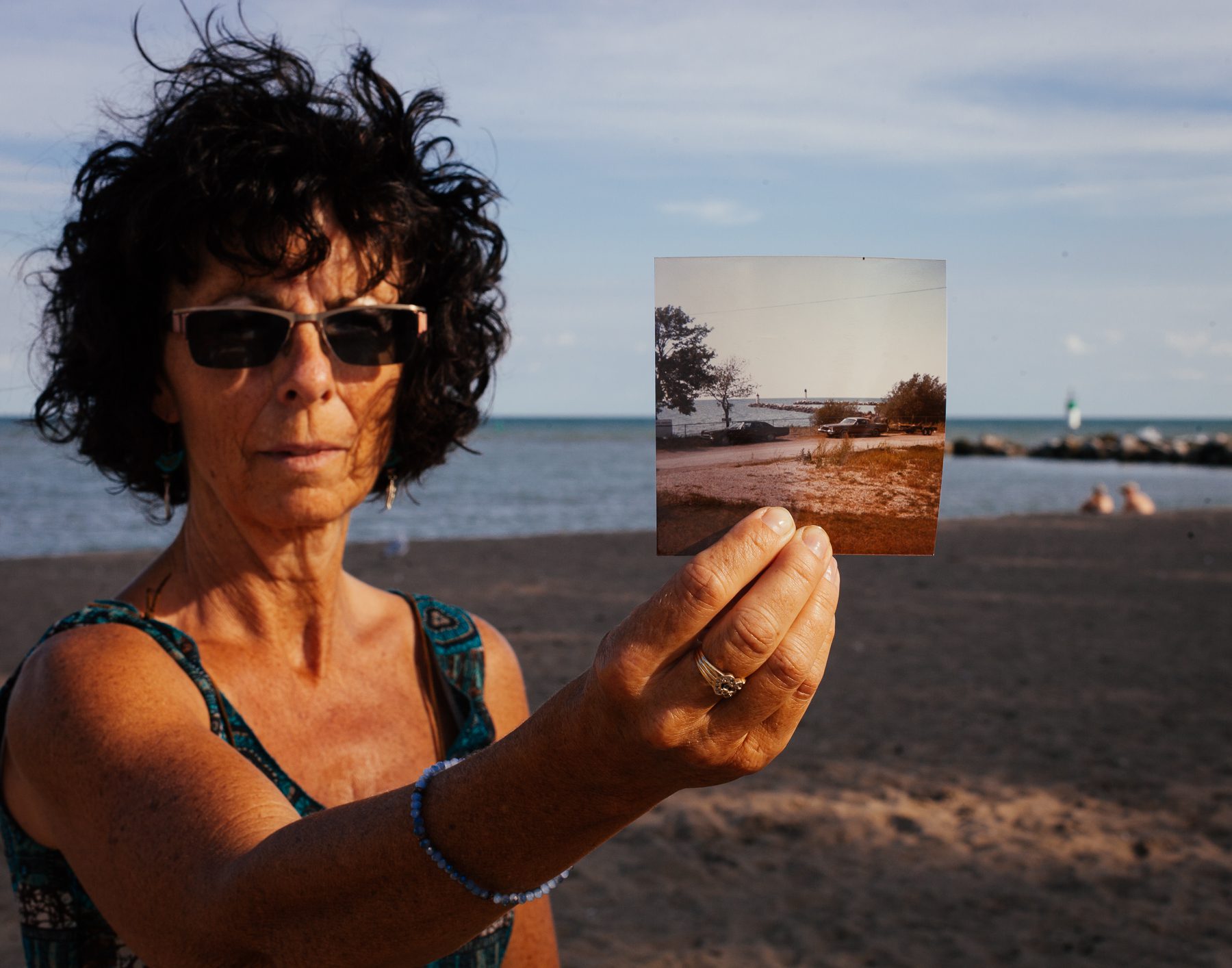 Sandra stands at the original location of the photograph she took of Cedar Beach while on her honeymoon