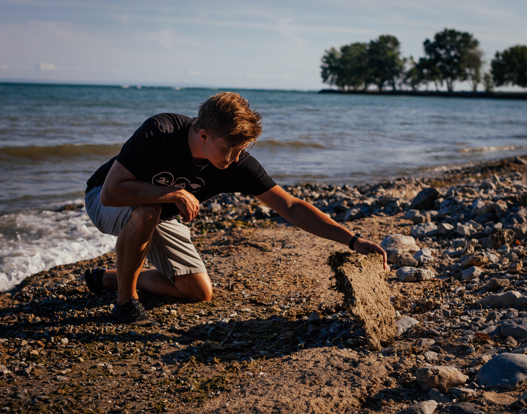 Gregary lifts a massive pile of dry Cladophora algae washed up on the shore Lorraine Bay in Port Colborne.