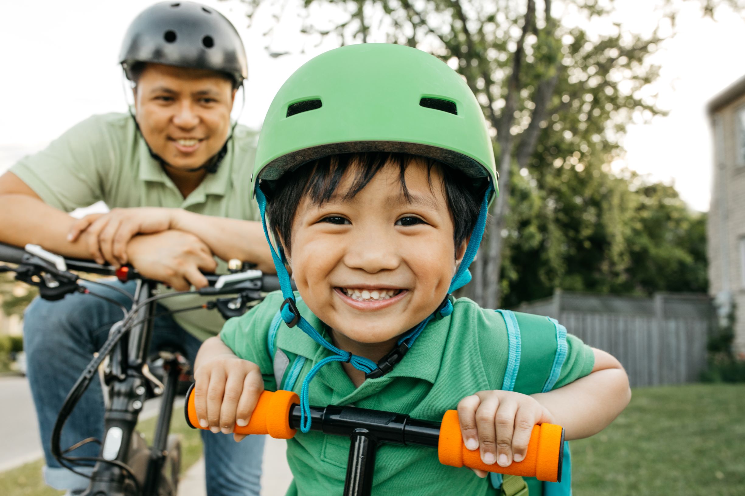 a child riding a bike grins happily at the camera