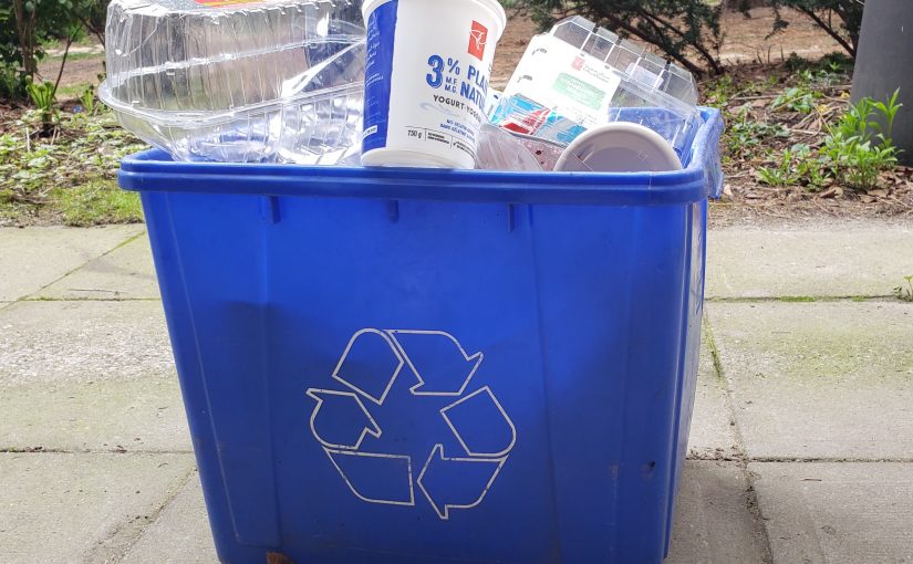 A recycling bin overflowing with plastic packaging.
