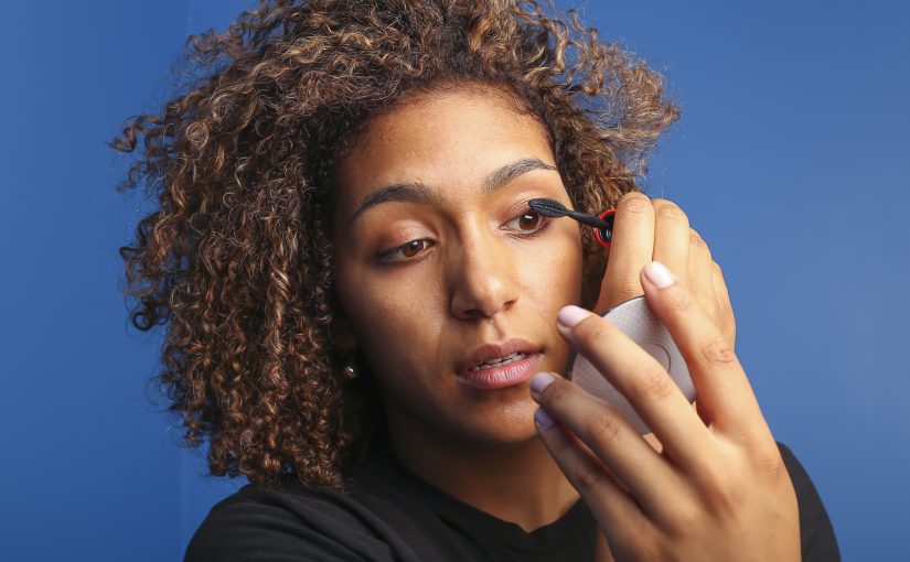 woman applying mascara containing PFAS