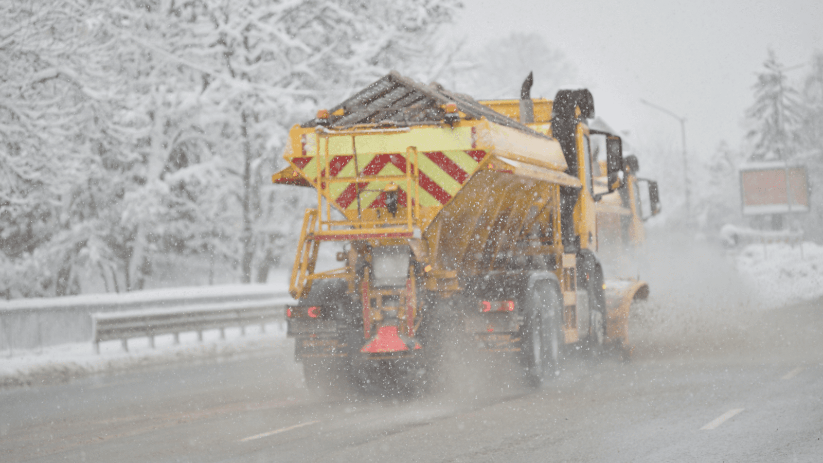 A truck dumps road salt onto the highway