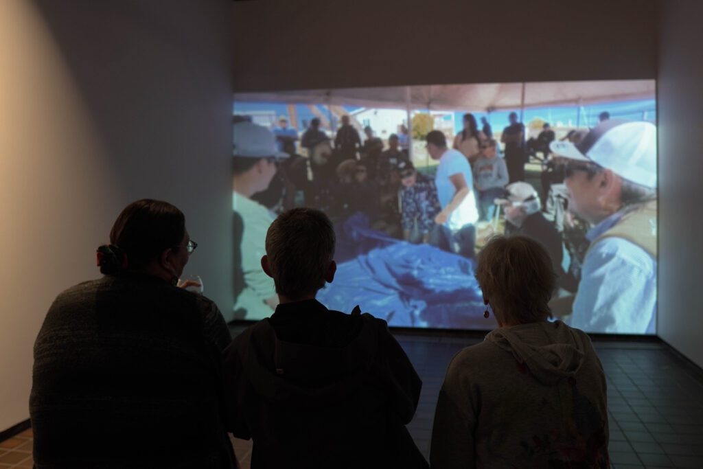 people watching a projection of community photos