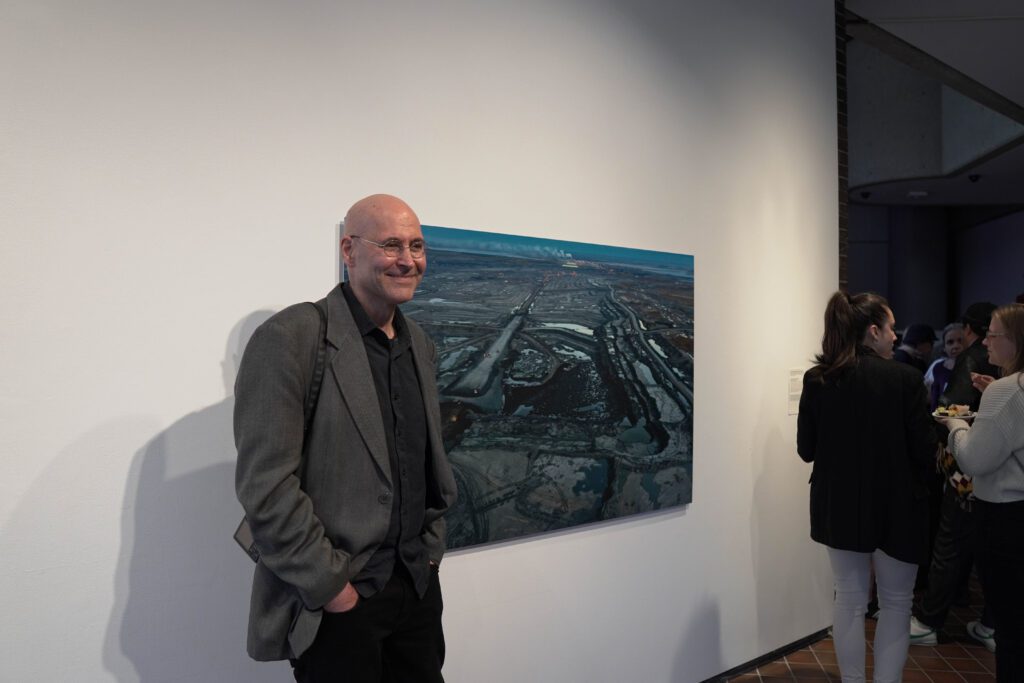 man standing beside an art photograph 